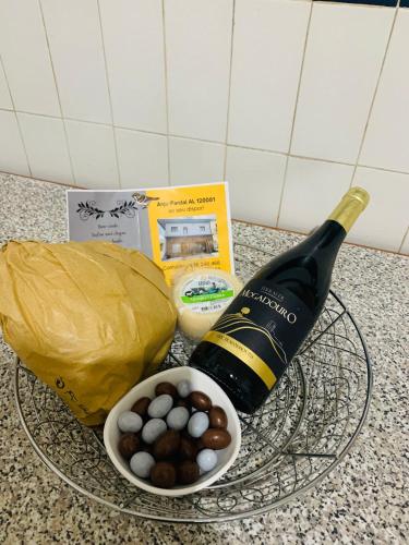 a glass plate with a bottle of wine and a bowl of balls at Anjú-Pardal in Mogadouro