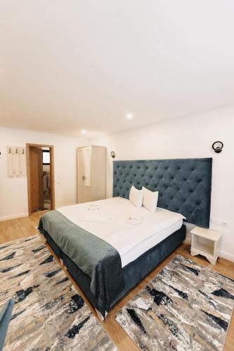 a bedroom with a large bed with a blue headboard at Royal Alpin Crown in Cavnic