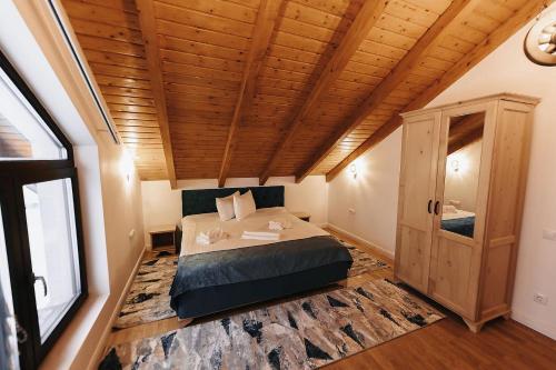 a bedroom with a bed and a wooden ceiling at Royal Alpin Crown in Cavnic