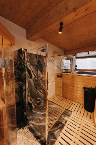 a sauna with a glass shower in a room at Royal Alpin Crown in Cavnic