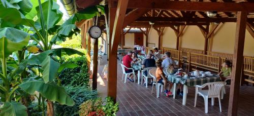 um grupo de pessoas sentadas em mesas em um restaurante em Korona Panzió em Balatonberény