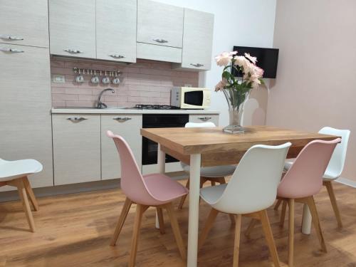 a kitchen with a wooden table and pink chairs at Casa Belvedere in Agrigento
