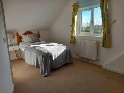 1 dormitorio con cama y ventana en Secluded Cornish farmhouse en Liskeard