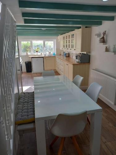 a kitchen with a white table and chairs in a room at Rural Cornish farmhouse in Liskeard