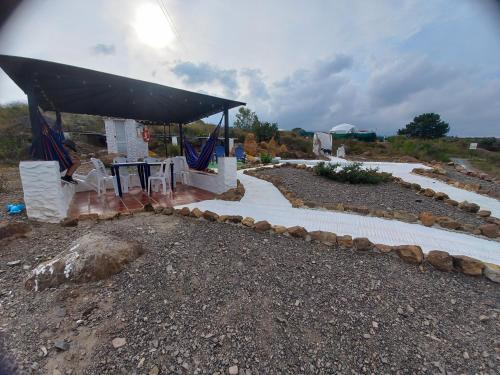 a pavilion with a stone walkway in a field at Monarca Azul Glamping in Villa de Leyva