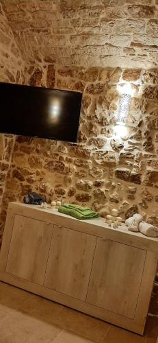 a counter in a room with a stone wall at Dimora Cleó in Putignano