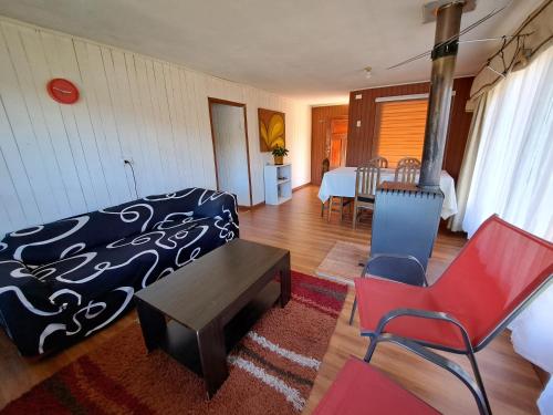 Schlafzimmer mit einem Bett, einem Tisch und Stühlen in der Unterkunft Camping & Cabaña Los Arrayanes Niebla in Valdivia