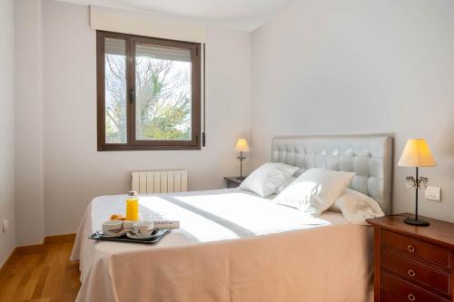 1 dormitorio con 1 cama blanca grande y ventana en Apartamento Go - La Ermita, en Arroyo de la Encomienda