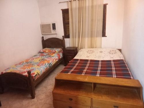 a bedroom with two beds and a dresser in it at Flia Perez Derrache in Ituzaingó