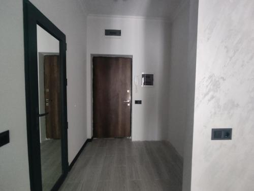 un pasillo vacío con una puerta y un espejo en Spacious Apartment in Yerevan, CENTRE en Ereván