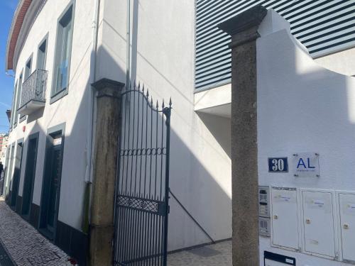 a white building with a gate on a street at Cube30 Águeda - Alojamento Local 1 in Águeda