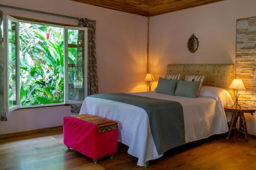 um quarto com uma cama grande e uma janela em Chalet Santacruz, Casa entera en la naturaleza em Nueva Loja