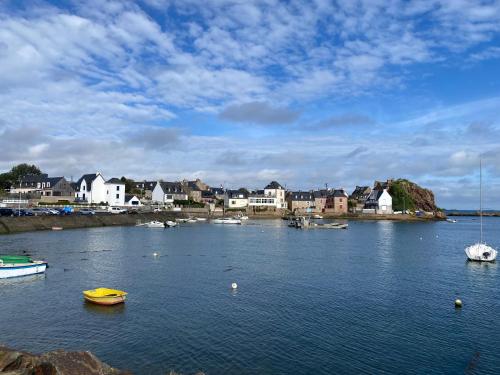 a body of water with boats in it with houses at Petit Coin du Port in Ploubazlanec