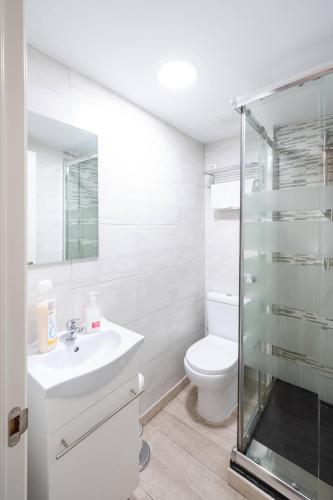 a white bathroom with a toilet and a sink at Apartamentos GO - Leopoldo Cano Center in Valladolid