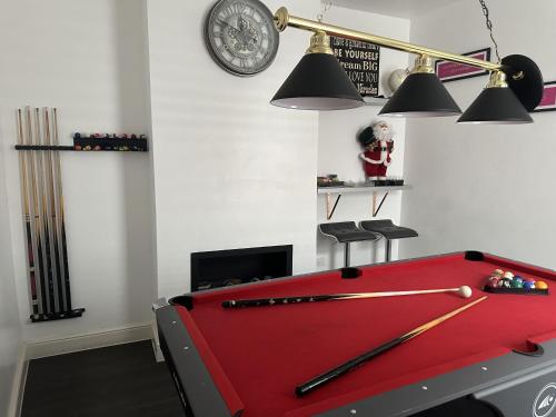a room with a pool table with bats on it at House - Sleeps 6 - Garden - Seaside - Pet Friendly in Great Yarmouth