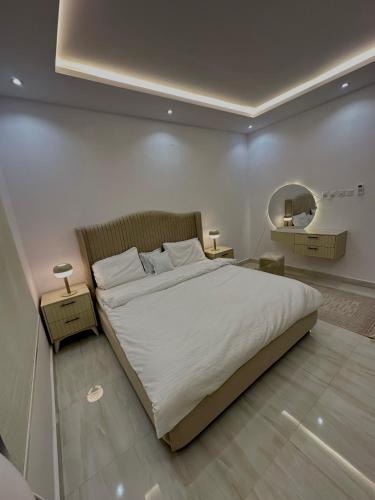 a bedroom with a large bed and a mirror at شقة مودرن غرفه وصاله in Riyadh