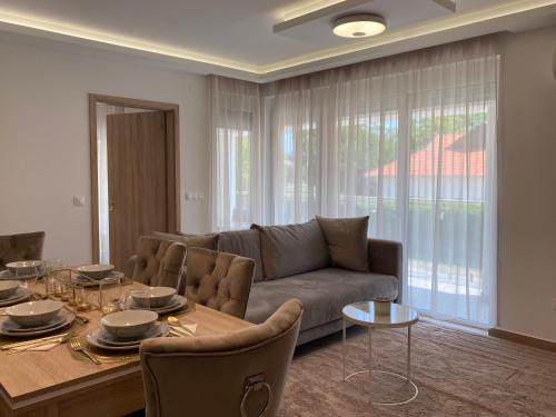 - un salon avec un canapé et une table dans l'établissement Sunshine Homes Luxury Apartmanok, à Zamárdi