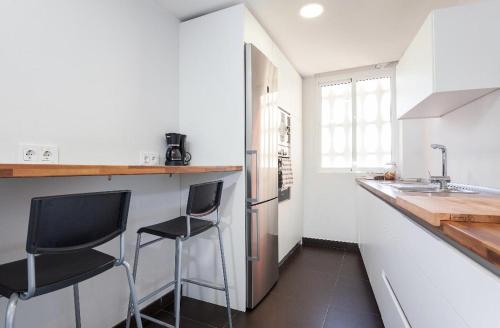 una cocina con 2 sillas negras y una barra de cocina en VISTAS AL MAR, en Aguadulce