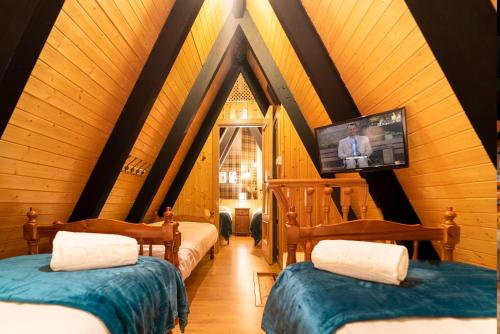 Habitación con 2 camas y TV en el ático. en PENTHOUSE IN THE CLOUDS & PARKING, en Sierra Nevada