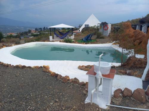 a swimming pool in a yard with a house at Monarca Azul Glamping in Villa de Leyva