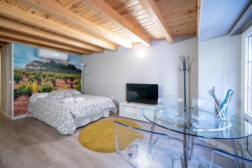 ein Schlafzimmer mit einem Glastisch, einem Bett und einem TV in der Unterkunft Apartamentos GO - Leopoldo Cano Center in Valladolid