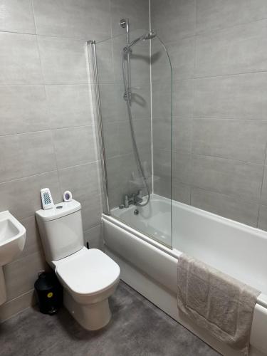 a bathroom with a shower and a toilet and a bath tub at The Landmark Brierley Hill in Dudley