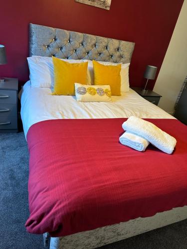 a bed with two towels on a red blanket at The Landmark Brierley Hill in Dudley