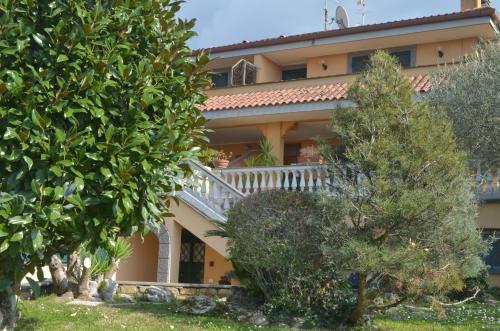 a house with a staircase and trees in front of it at Entire apartment in villa with parking in Frascati