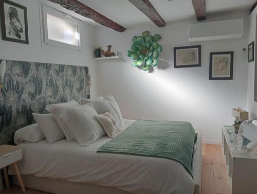 - une chambre avec un lit blanc et une couverture verte dans l'établissement Appartement Vue Notre Dame + extérieur verdoyant, à Marseille