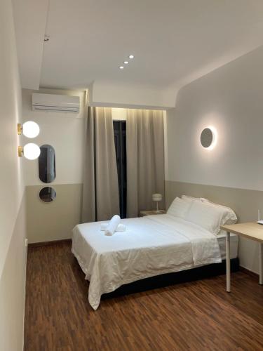 1 dormitorio con 1 cama blanca grande y escritorio en K Avenue by Tiara, en Donggongon