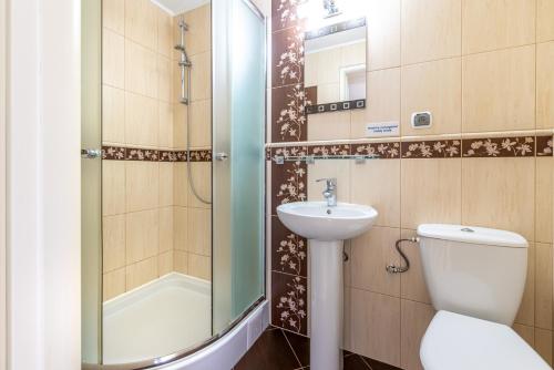 a bathroom with a toilet and a sink and a shower at Dom Gościnny Bursztynek in Krynica Morska