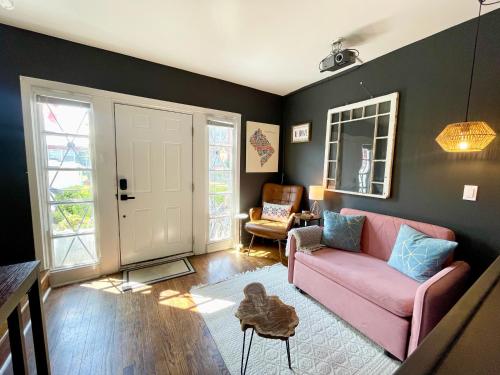 sala de estar con sofá rosa y silla en Capitol Hill Carriage House, en Washington