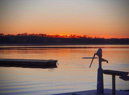 a sunset over a body of water with a dock at Haus Fabjerg in Lemvig