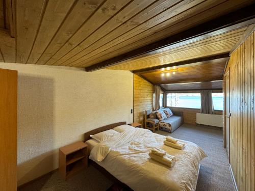 a bedroom with a bed with two towels on it at Villa Raiski kyt in Dospat