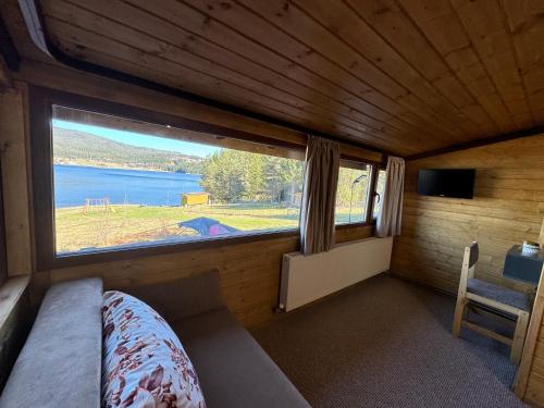 a bedroom with a large window in a cabin at Villa Raiski kyt in Dospat