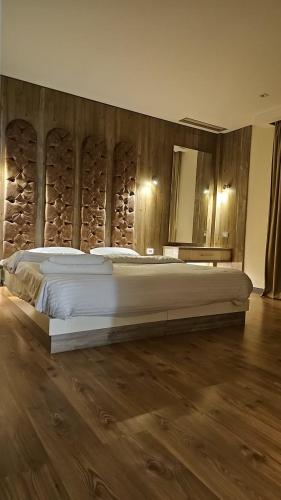 a bedroom with a large bed with a wooden wall at Sheraton Ocean 503 - Without Pool access in Cairo