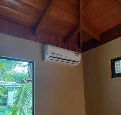 a air conditioner in a room with a wooden ceiling at Surf Shack Room #3 in Pavones