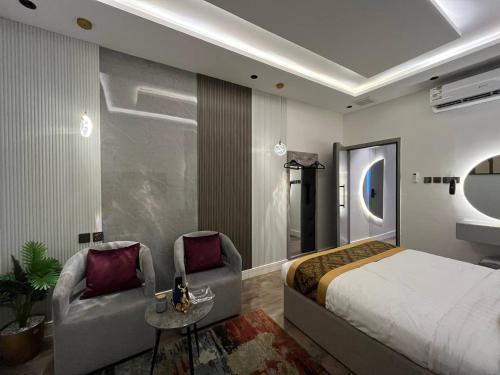 a bedroom with a bed and two chairs at استديو البوليفارد مدخل خاص دخول ذاتي in Riyadh