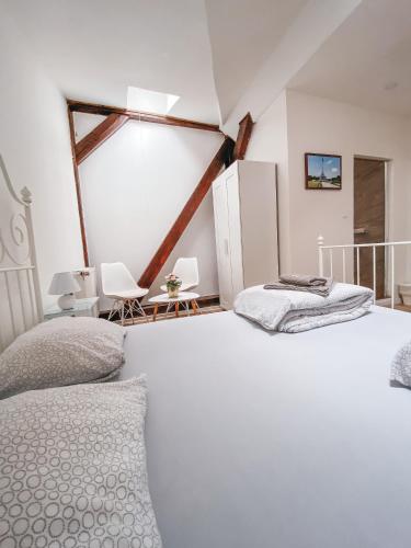 a bedroom with a large white bed and two chairs at Blue Lotus Apartments in Bratislava