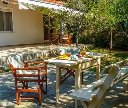 a table and chairs with food on a patio at Garden Ηouse N°3 in Plomarion