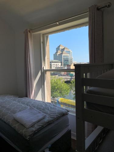 una camera da letto con finestra affacciata sulla città di Eden Quay Guesthouse Private Rooms a Dublino