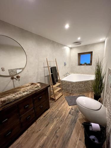 a bathroom with a tub and a sink and a mirror at Haus Tupferl in Niedernsill
