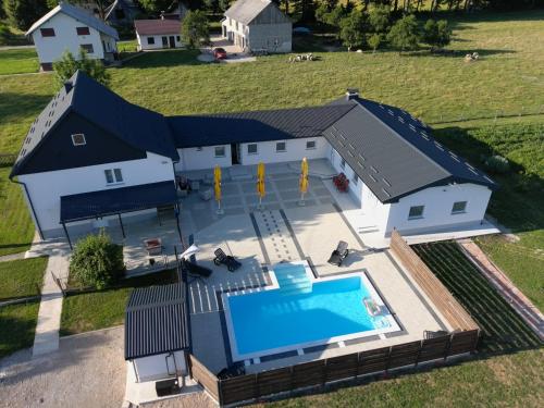 een luchtzicht op een huis met een zwembad bij Apartmani Albatros in Perušić