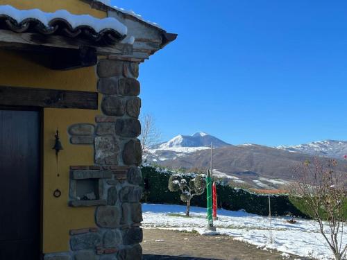a door of a building with a snow covered mountain at Casa di campagna nel Parco del Pollino in Teana