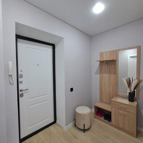 um quarto com uma porta, um banco e um espelho em Риддер, 4 микрорайон, дом 24. em Lenīnogorsk