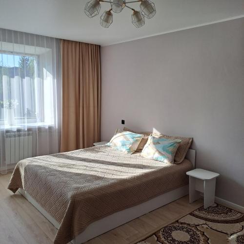 a bedroom with a bed and a window at Риддер, 4 микрорайон, дом 24. in Lenīnogorsk