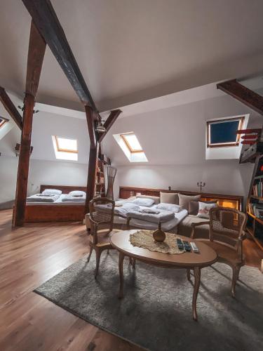 a room with two beds and a table and a couch at Blue Lotus Apartments in Bratislava