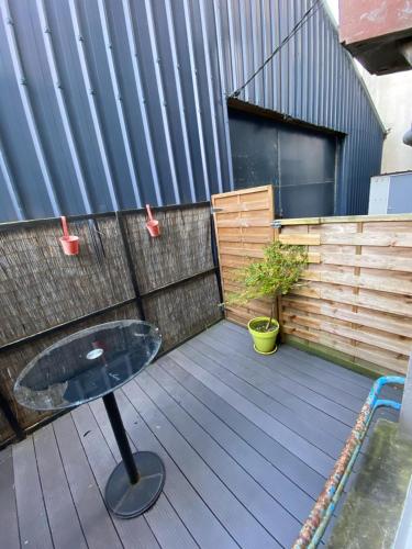 d'une terrasse avec une table et une clôture. dans l'établissement Duplex proche centre-ville, à Brest