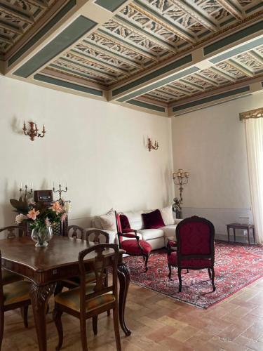 a living room with a couch and a table and chairs at Palazzo Lauri Spoleto in Spoleto