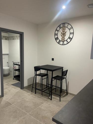 une salle à manger avec une table et une horloge au mur dans l'établissement Studio Kosy Gare Part Dieu, à Lyon